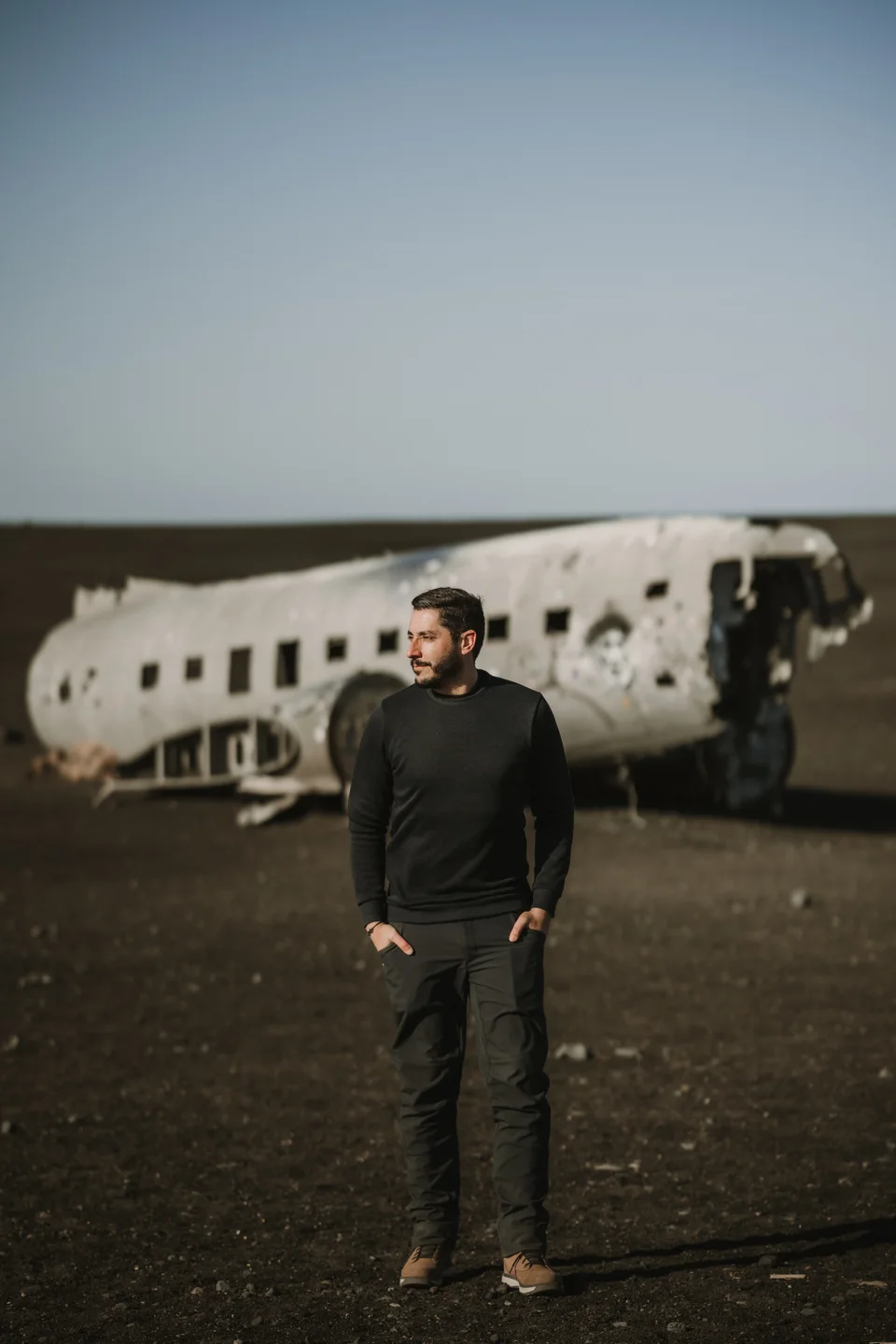 Retrato en color de David Bresó ante un avión abandonado.