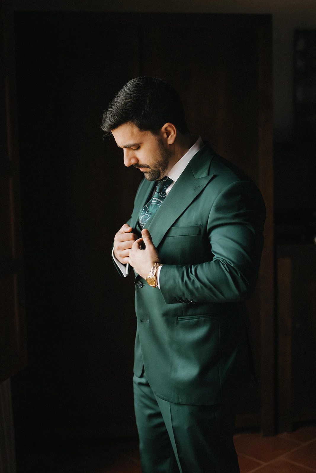 Germán se ajusta el traje junto a la luz de una ventana. Fotografía de David Bresó.
