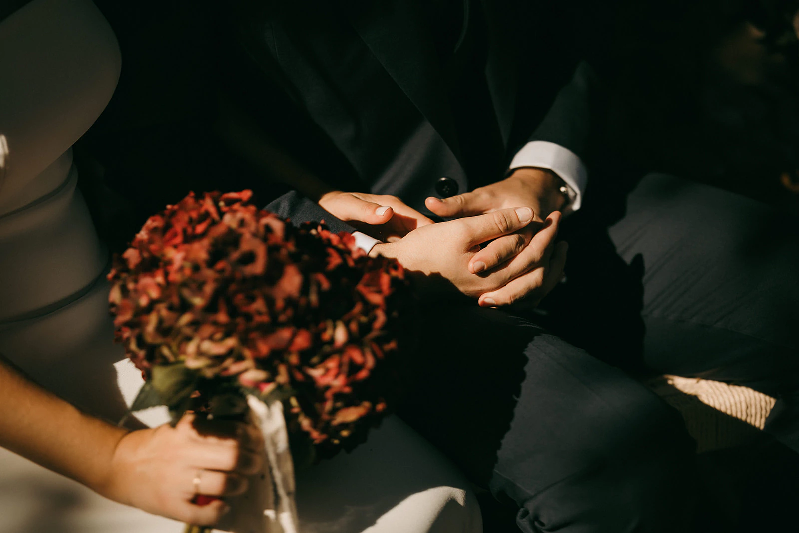 Las manos de Sergio y Claudia junto al ramo de la novia. Fotografía de David Bresó.